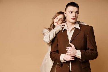 Güzel kız arkadaşının yanında poz veren güler yüzlü yakışıklı genç adam kameraya bakıyor.