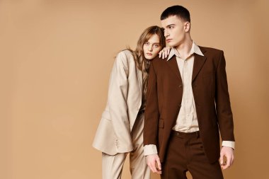 Güzel kız arkadaşının yanında poz veren güler yüzlü yakışıklı genç adam kameraya bakıyor.