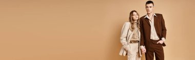chic young woman in stylish suit posing with her handsome boyfriend and looking at camera, banner clipart