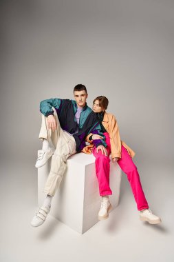 Canlı bombacı yakışıklı adam beyaz küpteki güzel kız arkadaşının yanındaki kameraya bakıyor.