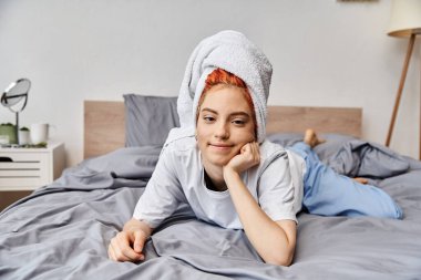 joyous beautiful queer person with hair towel chilling in her bed and smiling at camera, morning clipart