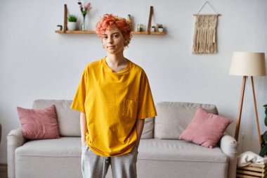 İyi görünümlü, neşeli, neşeli, spor kıyafetli ve kameraya bakan biri.