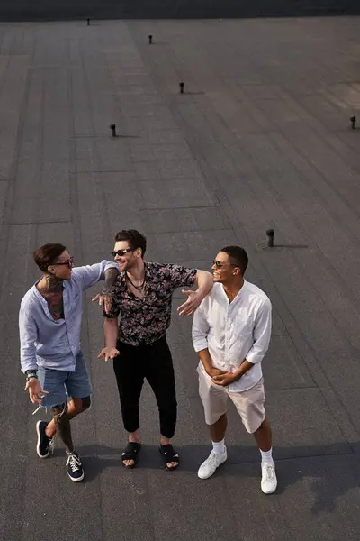 Tres Alegres Amigos Multirraciales Trajes Vibrantes Posando Azotea Mirándose Unos — Foto de Stock
