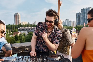 Moda güneş gözlüklü çok kültürlü neşeli arkadaşlar çatıdaki partide DJ 'lik yaparak eğleniyorlar.