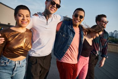 cheerful multicultural friends in casual clothes with sunglasses having fun and smiling at camera clipart