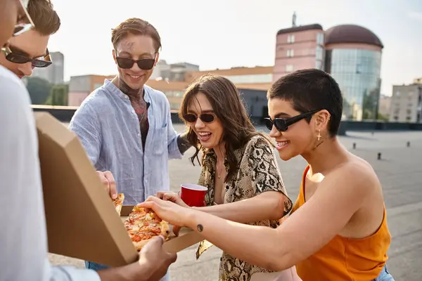 multicultural joyous people with stylish sunglasses eating pizza and drinking cocktails at party