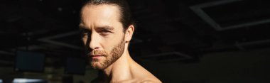 Spor salonunda spor yaparken vücudunu gösteren kaslı bir adamın detaylı görüntüsü..