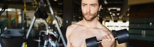 Skjortlös Man Visar Upp Sin Muskelfysik Medan Han Håller Hanteln — Stockfoto