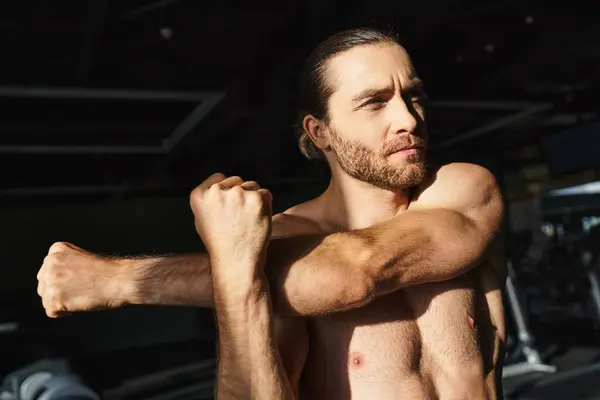 Shirtless Man Showcasing Muscular Physique Flexing Biceps Gym Environment Confidence kuvapankkikuva