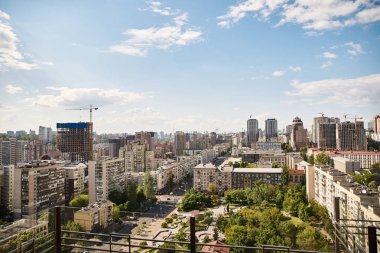 Altında, gökdelenlerin, hareketli sokakların ve hareketli şehir hayatının sergilendiği yüksek bir binadan bakıldığında resim gibi bir şehir uzanır.