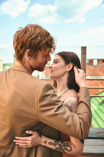 A man and a woman stand together, side by side, creating a sense of unity and connection in their presence