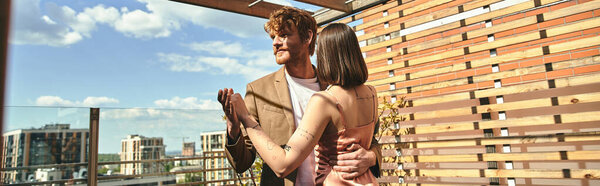 Мужчина и женщина стоят вместе на крыше, с видом на город внизу
