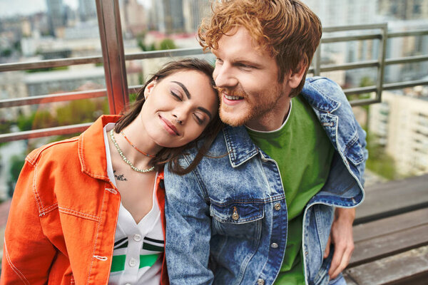 Мужчина и женщина мирно сидят на скамейке, наслаждаясь компанией друг друга под сумерками