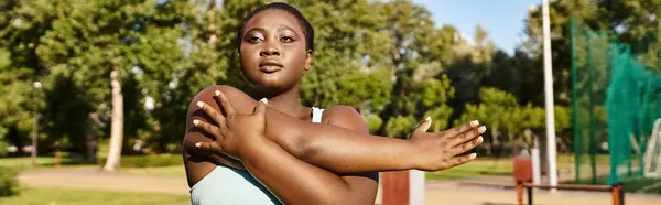 スポーツウェアに興味深いアフリカ系アメリカ人女性の彫像は 公園で背の高い自信と強さを誇っています — ストック写真