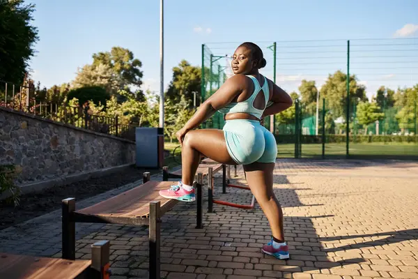African American Woman Sportswear Showcasing Body Positivity Leans Bench While — Stock Photo, Image