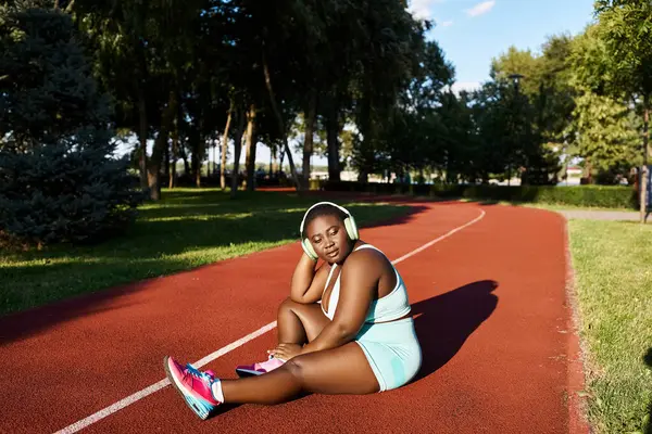 Spor Giyimli Afrikalı Bir Amerikalı Kadın Tenis Kortunda Oturuyor Elinde — Stok fotoğraf