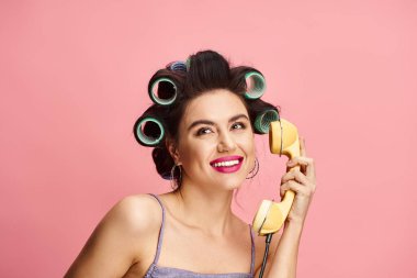 Güzel bir kadın zarif bir şekilde retro telefonu tutuyor..