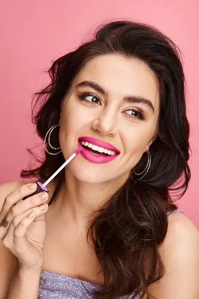 stock image A beautiful woman with natural beauty showcases pink lipstick on her lips against a vibrant backdrop.
