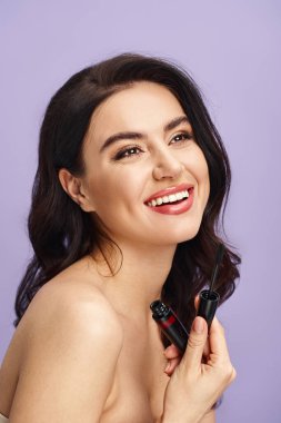 Parlak gülüşlü bir kadın maskara tutar.