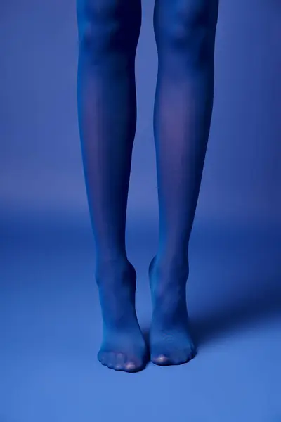 Young Woman Poses Vibrant Stockings Blue Background Studio Setting — Zdjęcie stockowe