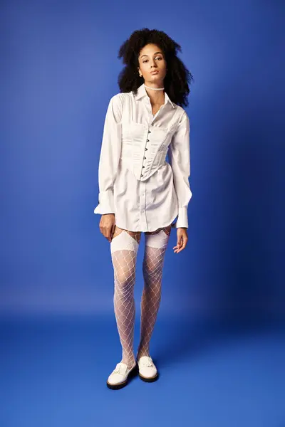 Young Woman White Shirt Fishnet Stockings Poses Vibrant Blue Background — ストック写真