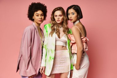 Aralarında Kafkas, Asyalı ve Afrikalı Amerikalıların da bulunduğu çeşitli kadınlar, pembe bir stüdyo geçmişine karşı birlikte duruyorlar..