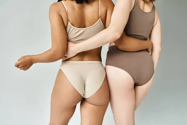 Two Beautiful Diverse Women Cozy Pastel Underwear Standing Side Side — стоковое фото