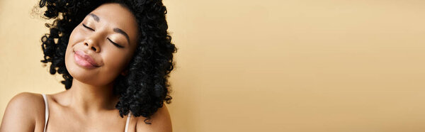 A woman with her eyes closed, wearing a bra in pastel colors.