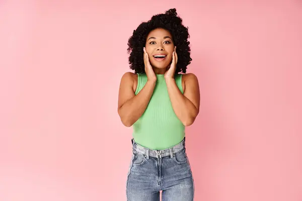 stock image A strikingly attractive diverse woman stands gracefully in front of a vibrant pink background.