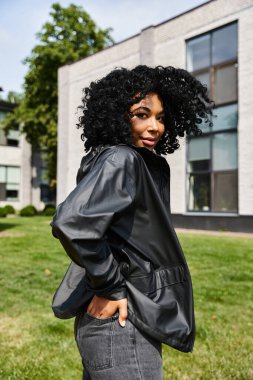 Modern bir binanın önünde kendine güvenen şık, değişik bir kadın..