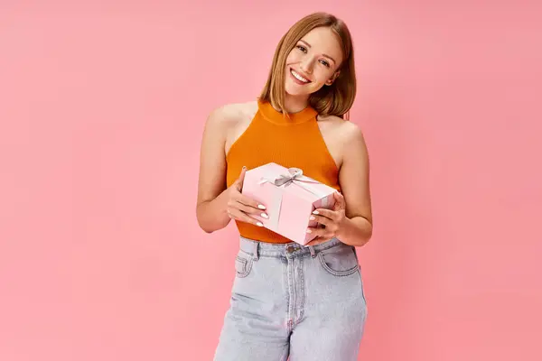 Woman Casual Attire Holding Pink Gift Box Smiling Warmly — स्टॉक फ़ोटो, इमेज