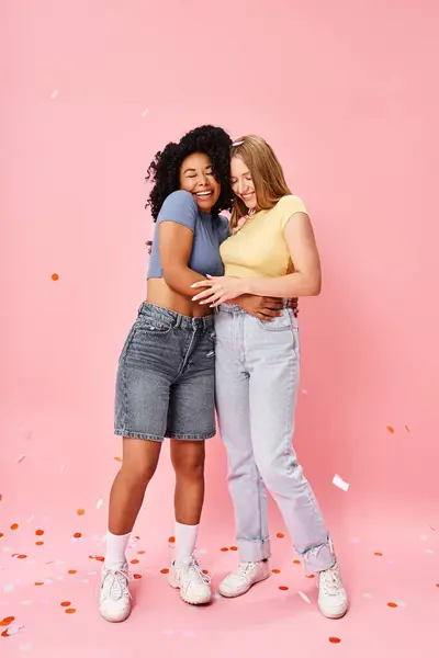 Duas Atraentes Mulheres Diversas Abraçam Calorosamente Frente Pano Fundo Rosa — Fotografia de Stock
