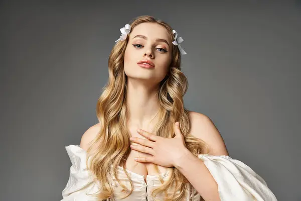 一位金发碧眼的年轻女子穿着飘逸的白色长袍 在演播室里流露出一种飘逸的美感 — 图库照片