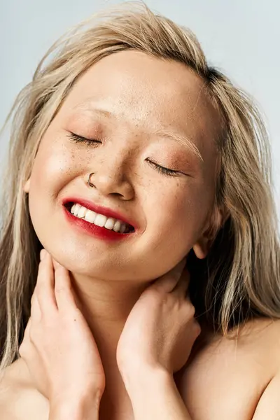 stock image Asian woman closes eyes, hands on chest in peaceful moment.