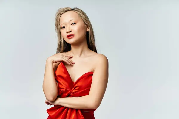 鮮やかな赤いドレスの魅力的なアジアの女性が写真のポーズを印象づける — ストック写真