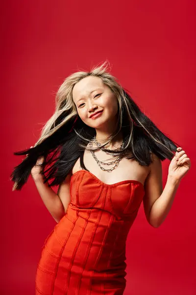 流れる赤いドレスのアジアの女性は彼女の長い髪の揺れと優雅にポーズします — ストック写真