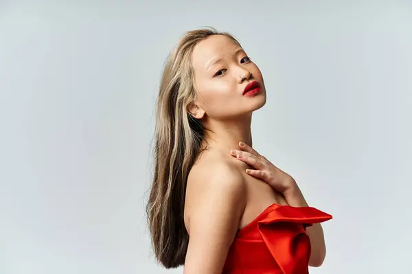 Captivating Asian Woman Vibrant Red Dress Strikes Pose 스톡 사진