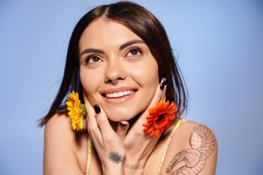 A young brunette woman radiates beauty as she wears a delicate flower in her hair in a striking studio portrait. clipart