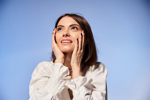 Молодая брюнетка с руками на лице, глубоко в мыслях и размышлениях в студии.