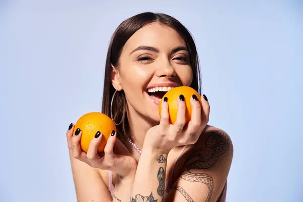 Young Woman Brunette Hair Delicately Holds Two Vibrant Oranges Her — Stock Photo, Image