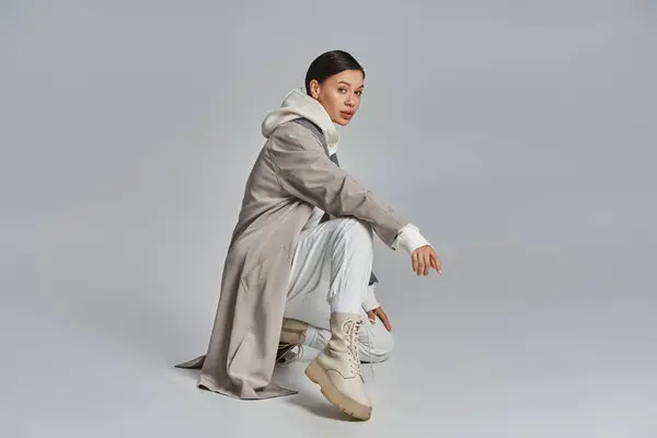 Young Stylish Woman Trench Coat Sitting Gracefully Studio Grey Background — Stock Photo, Image