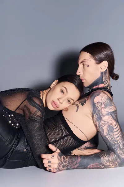 Young Stylish Couple Adorned Tattoos Lying Together Loving Embrace Grey — Stock Photo, Image