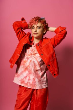 Kırmızı ceket ve kırmızı pantolon giyen genç bir kadın canlı bir elbise içinde göze çarpıyor..