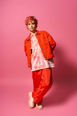 Genç kadın turuncu ceket ve kırmızı pantolon içinde göze çarpıyor..
