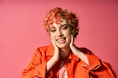 Turuncu ceketli şık bir kadın poz veriyor..