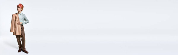 Необыкновенная женщина в костюме, позирующая на белом фоне.