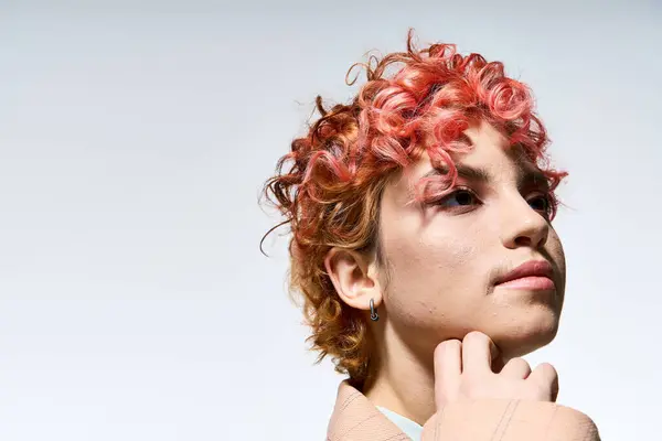 stock image A vibrant woman with red hair poses stylishly.