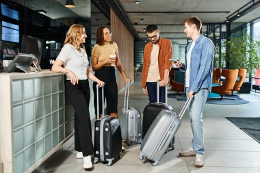 Çeşitli iş adamları gündelik giysiler içinde bir otel lobisinde bavullarıyla durup şirket gezileri için heyecanlılar..