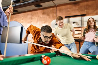 Successful startup team enjoying a game of pool in a stylish office, bonding and strategizing during a break. clipart