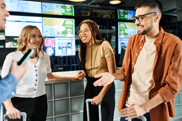 Multicultural colleagues in casual attire stand together in a hotel lobby during a corporate trip, facing a reception counter.
